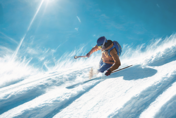 skifahrer fahrt durch den Schnee den Berg runter, perfekter sonnenschein